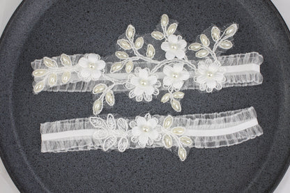 two garters with flowers and pearls on them