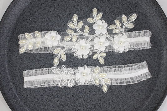 two garters with flowers and pearls on them