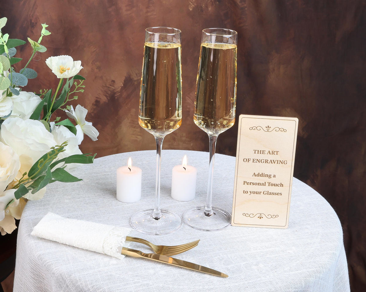 two glasses of champagne sitting on a table with a sign
