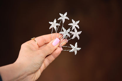 a person holding a small white flower in their hand