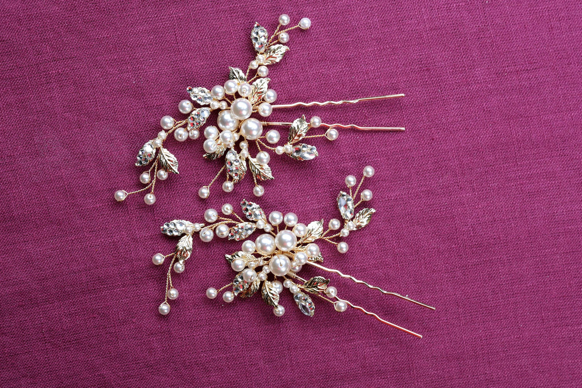 a close up of two hair pins on a purple surface
