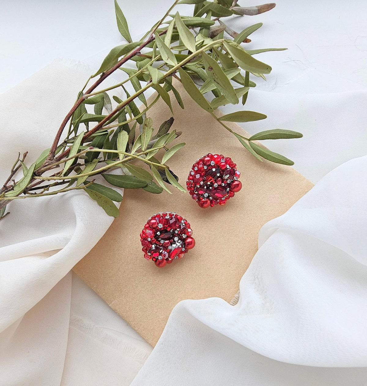 a pair of red and black beads sitting on top of a piece of paper