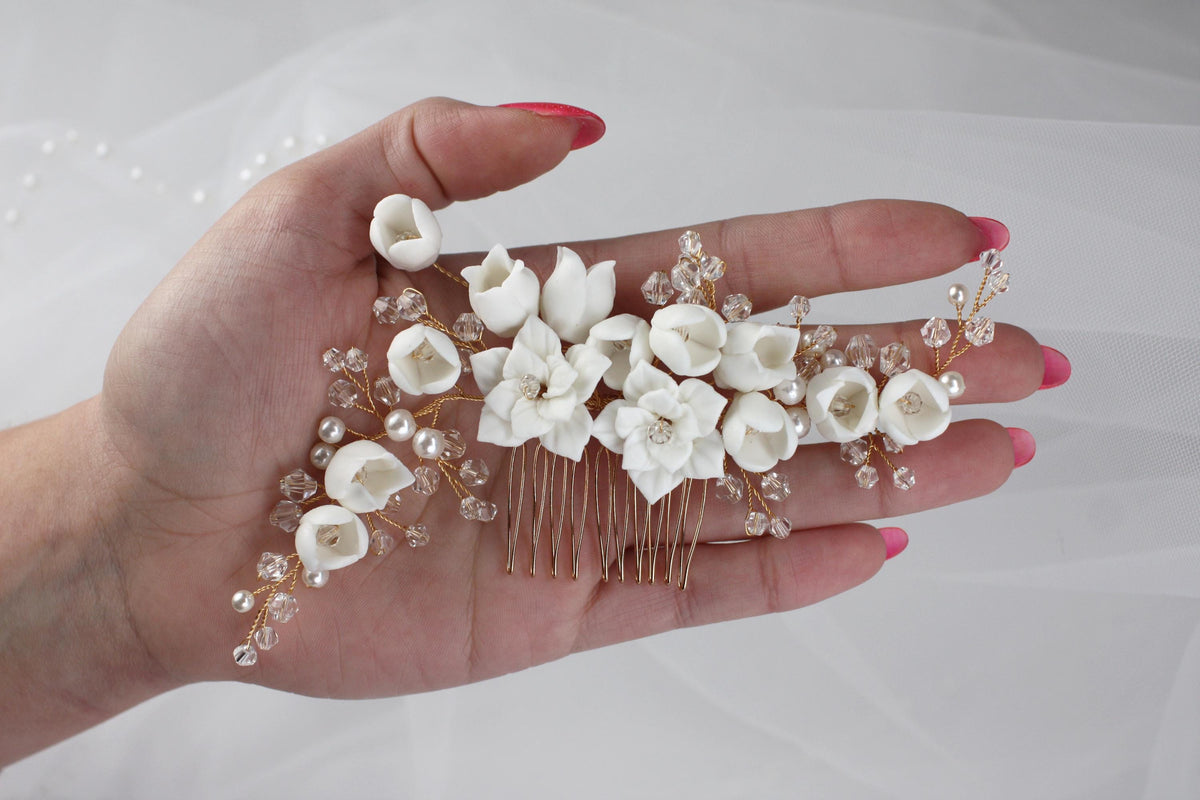 a woman's hand holding a bunch of white flowers