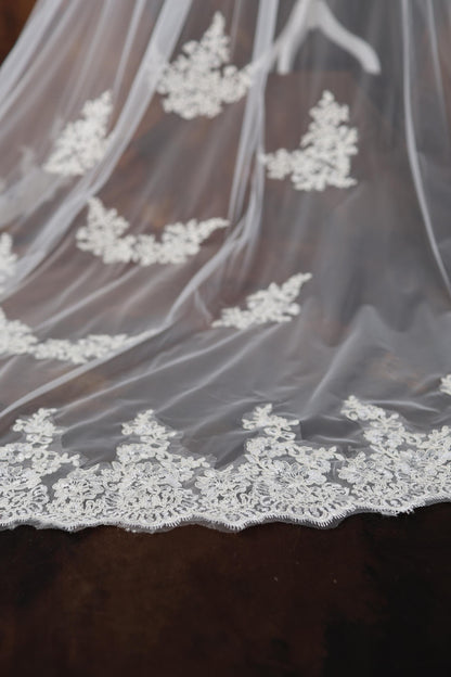 a wedding veil with white lace on it