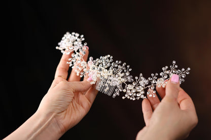 a woman is holding a comb with pearls on it