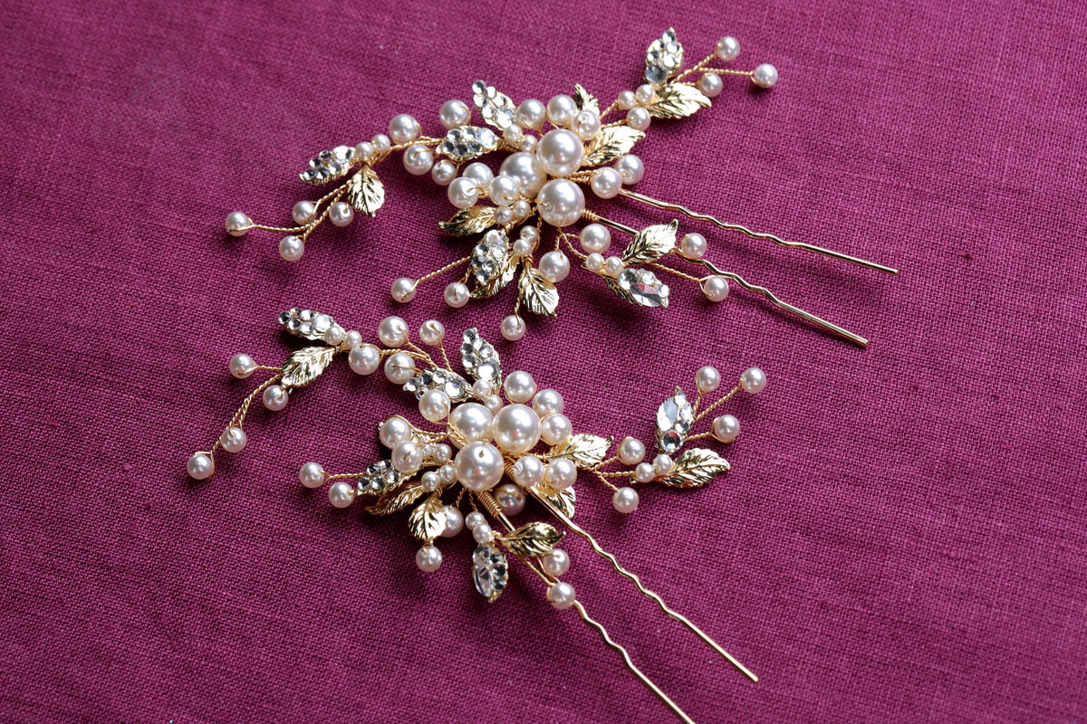 a close up of two hair pins on a purple cloth