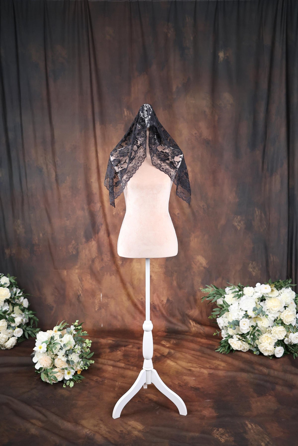 a white mannequin with a black scarf on top of it