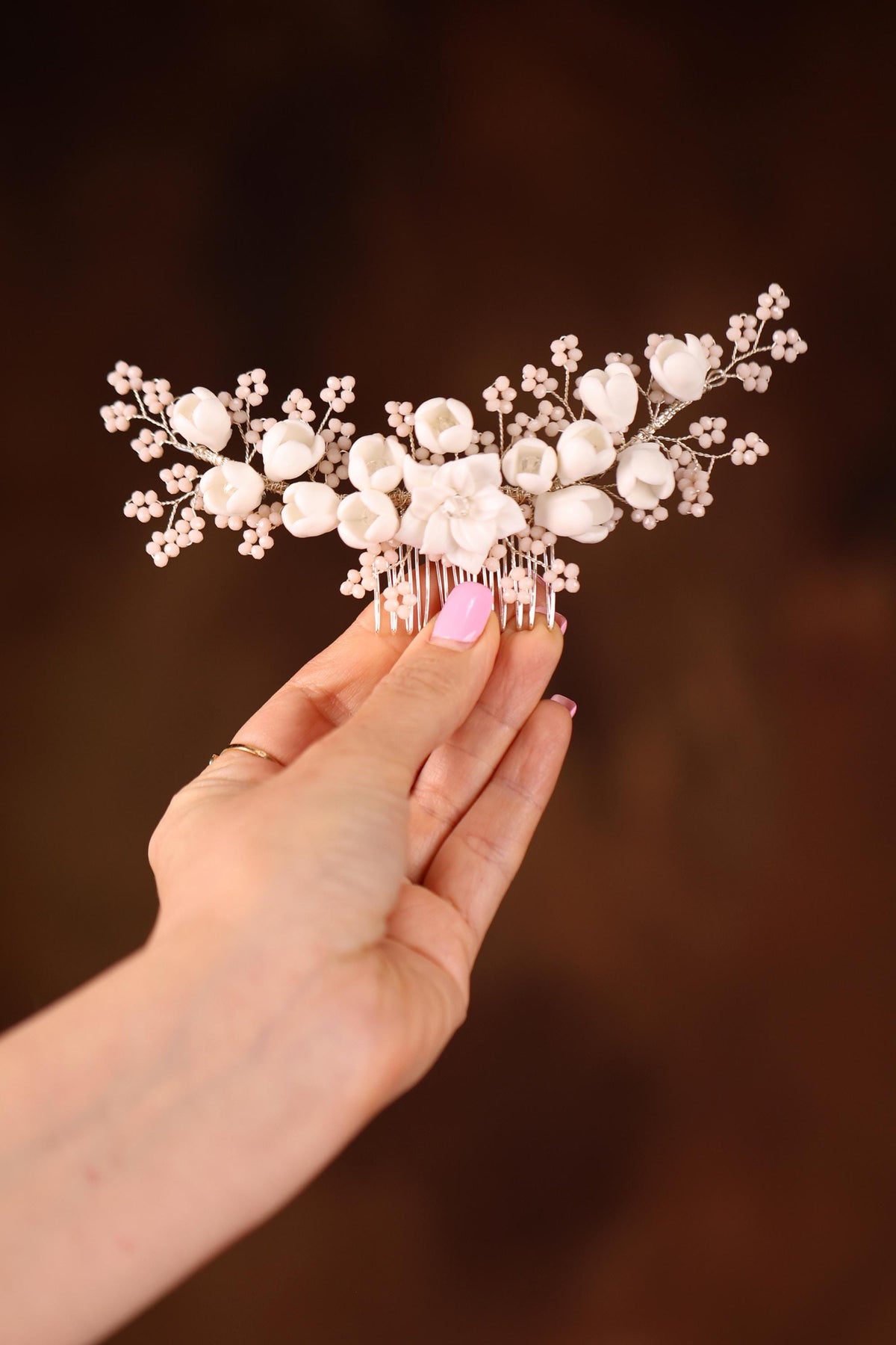 a hand holding a hair comb with flowers on it