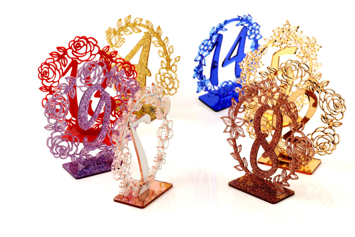 four decorative table number stands, each with a unique design and color scheme.