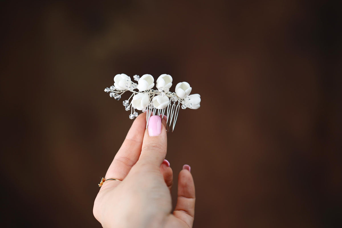 a woman's hand holding a hair comb with flowers on it
