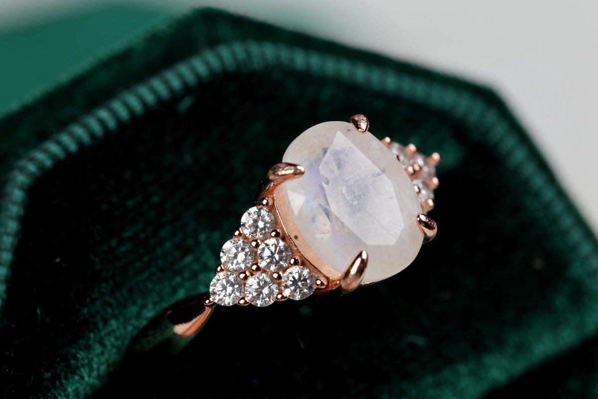 a ring with a large white stone surrounded by small diamonds