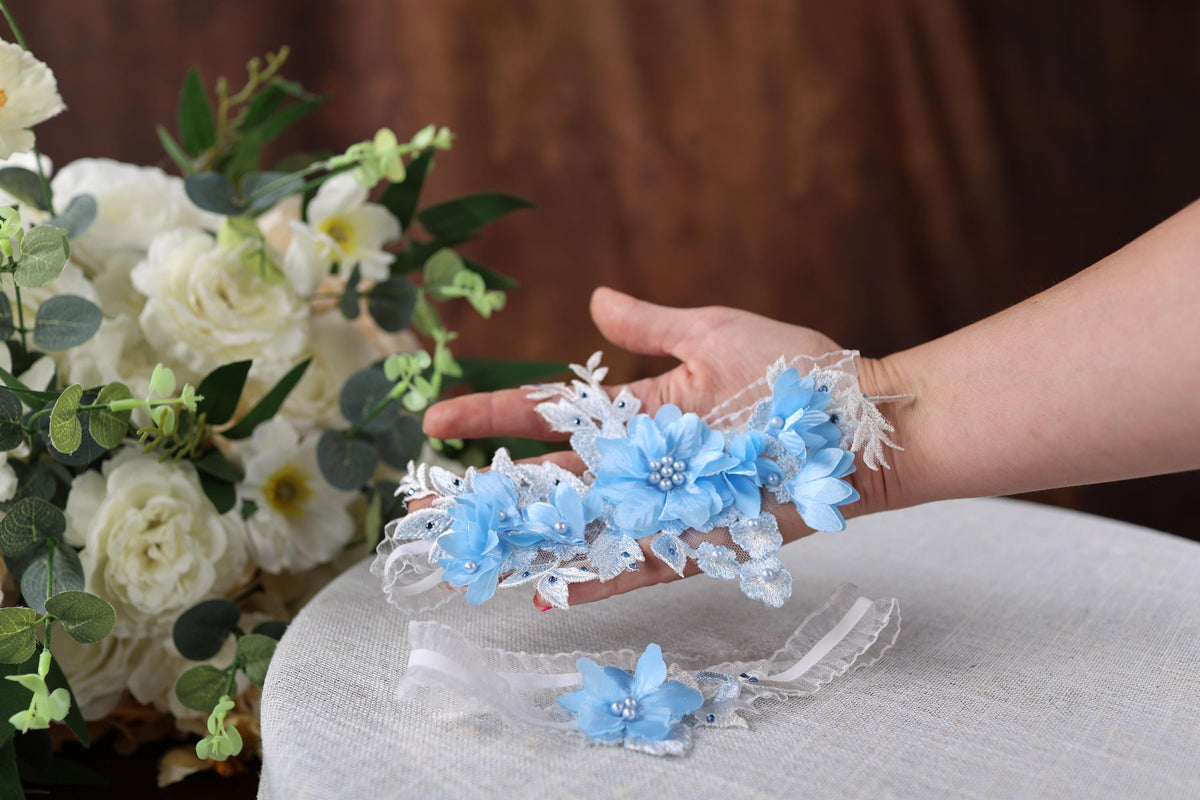 a woman's hand holding a bouquet of white and blue flowers