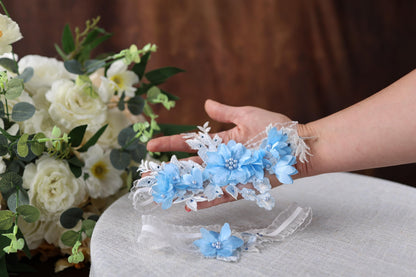 a woman's hand holding a bouquet of white and blue flowers