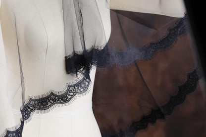 a white dress with a black lace trim