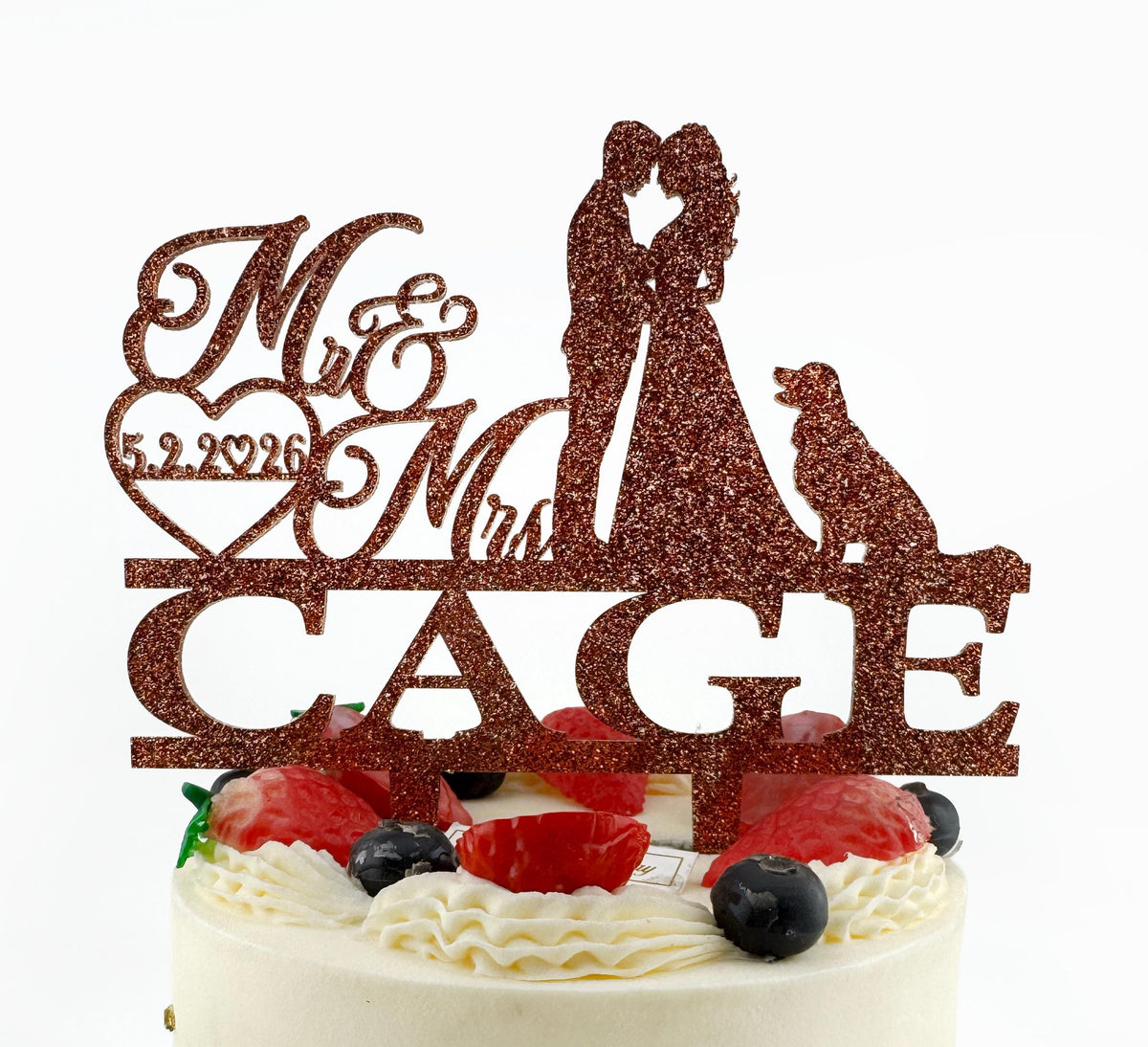 A wedding cake with a glittery topper that says "Mr & Mrs CAGE" and features silhouettes of a bride and groom embracing a dog.