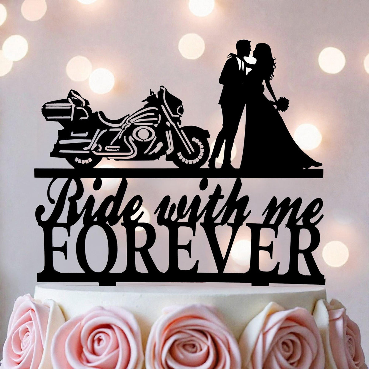 a wedding cake with a black silhouette of a couple embracing, a motorcycle, and the words "Ride with me Forever" written on the cake topper.