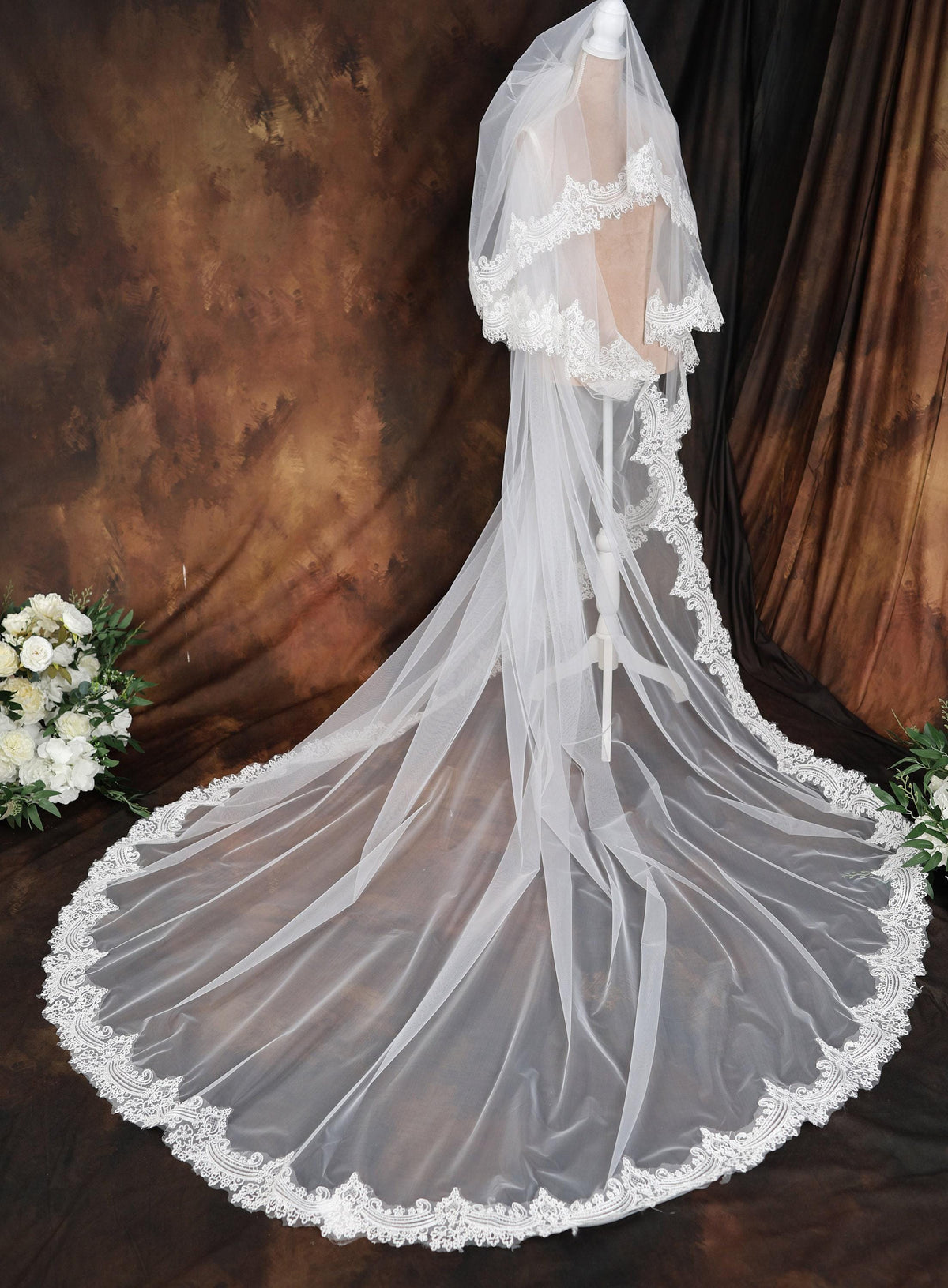 a wedding veil with a lace edge on a mannequin
