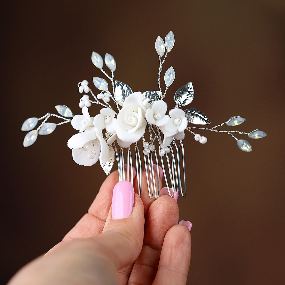 a hand holding a hair comb with flowers on it