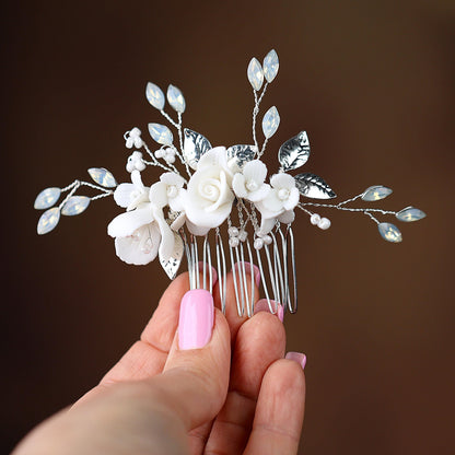 a hand holding a hair comb with flowers on it
