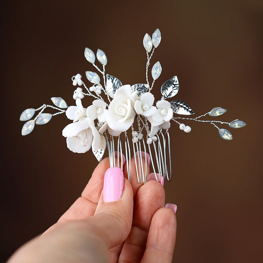 a hand holding a hair comb with flowers on it