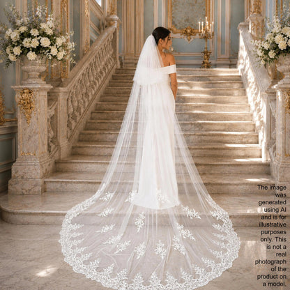 A bride in a white wedding dress with a long, flowing veil stands on a staircase in an ornate, gilded room.