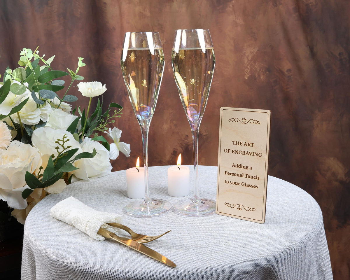 a table topped with two champagne flutes and a sign