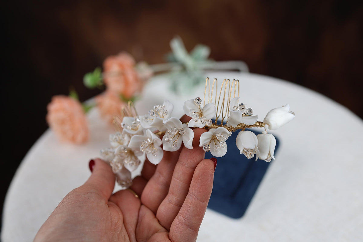 a hand holding a small white flower on a table