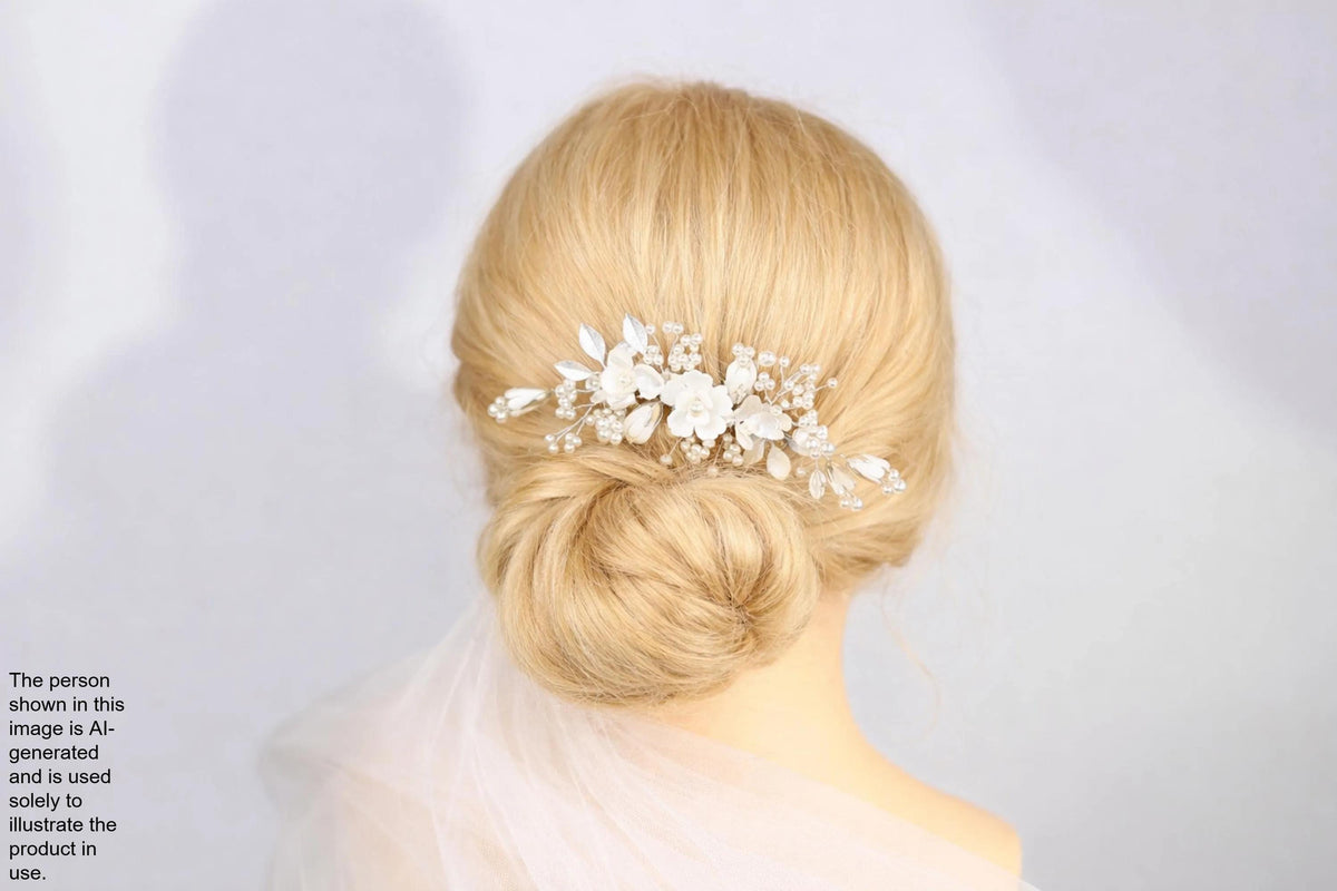 A woman with blonde hair styled in a bun, wearing a decorative hair accessory with white flowers.