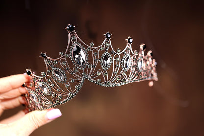 a close up of a person holding a tiara