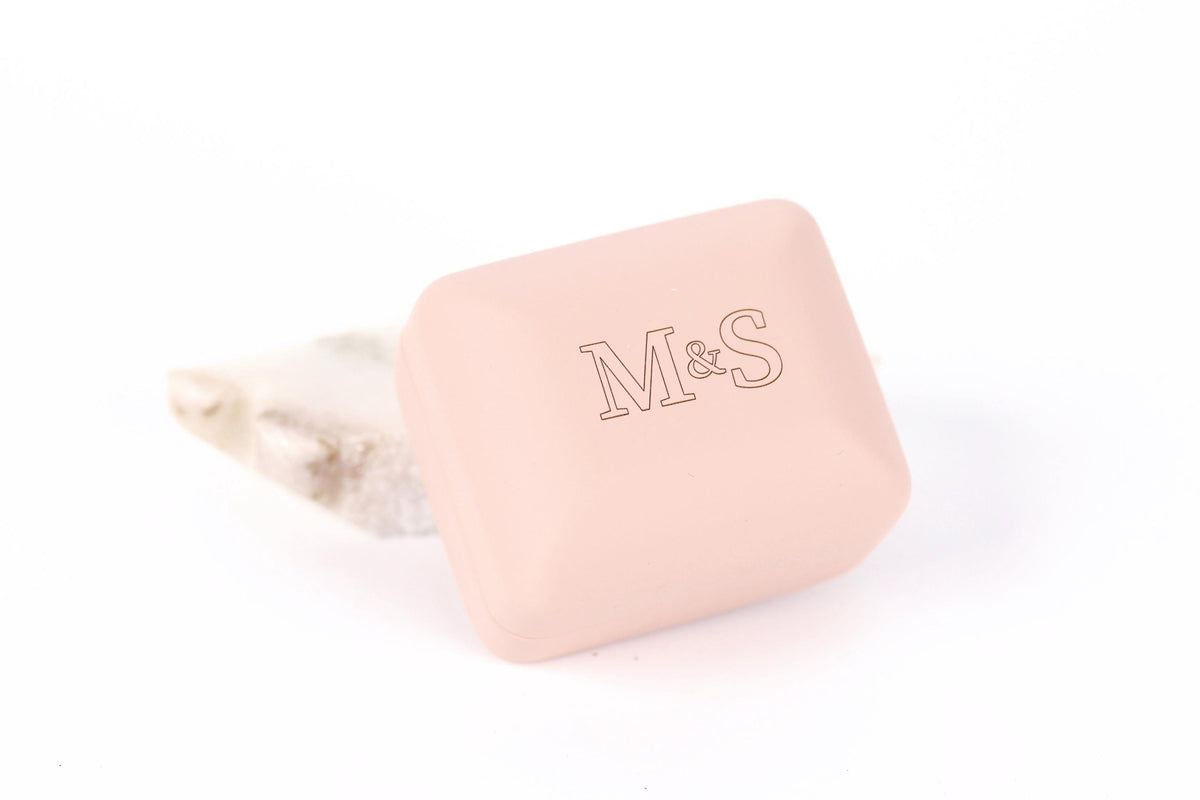 A pink rectangular box with the letters 'M&S' printed on it.