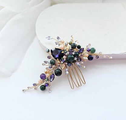 A decorative hair accessory with a gold-colored metal frame and a floral design, featuring a variety of colorful gemstones and beads.