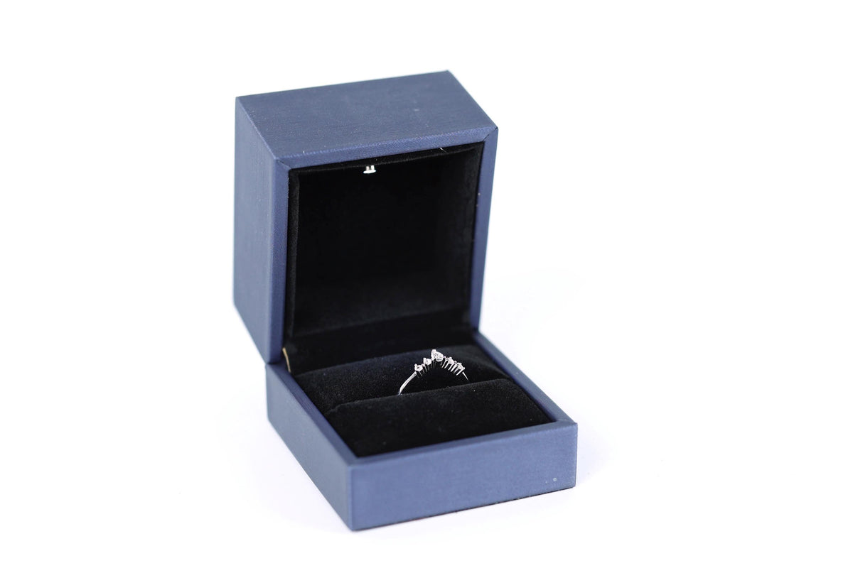 A blue jewelry box containing a silver ring.