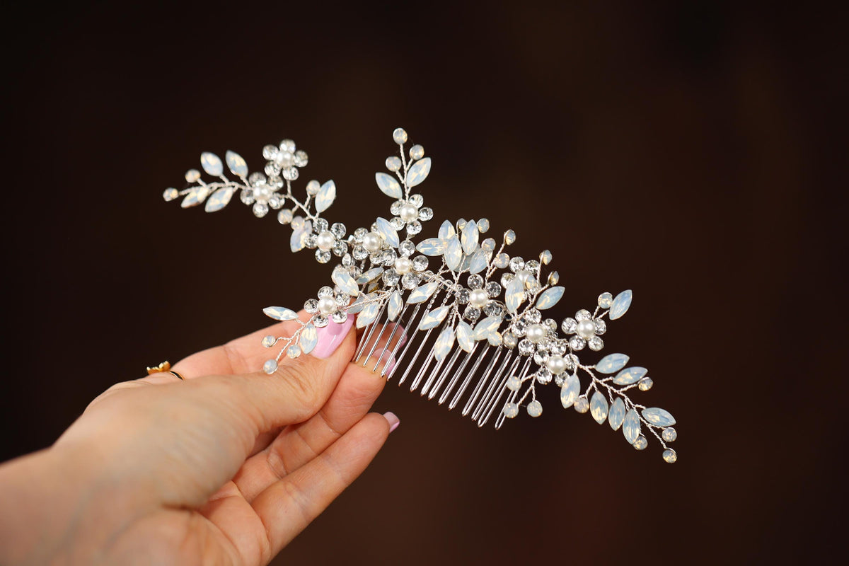 a woman holding a comb with flowers and leaves on it
