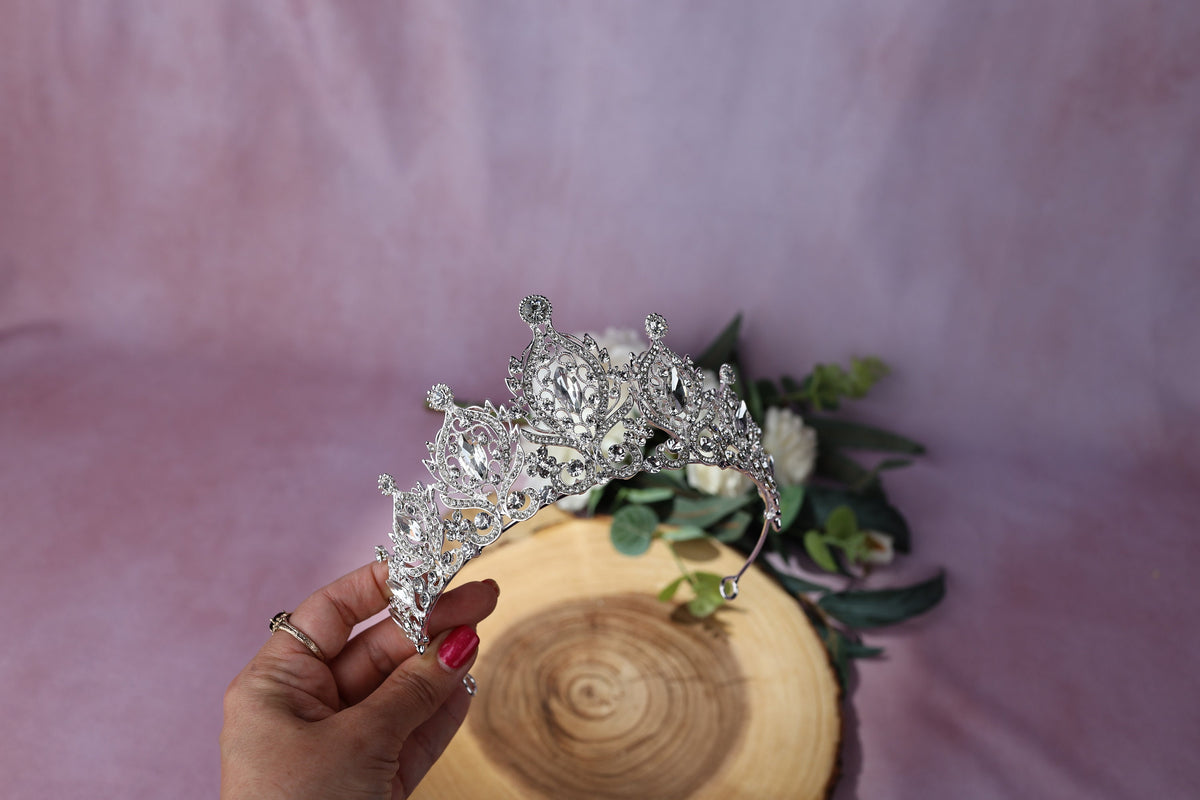 a woman is holding a tiara in her hand
