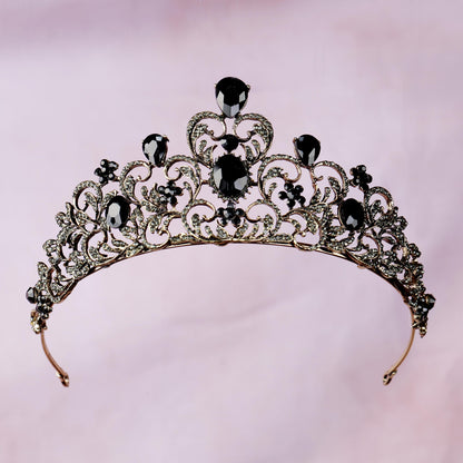 a tiara with black stones on a pink background