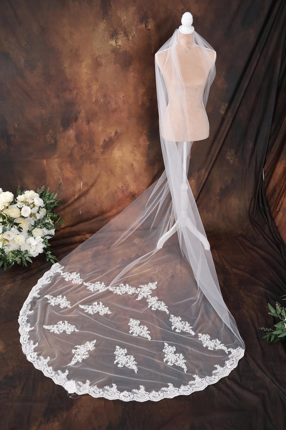 a wedding dress with a veil on a mannequin