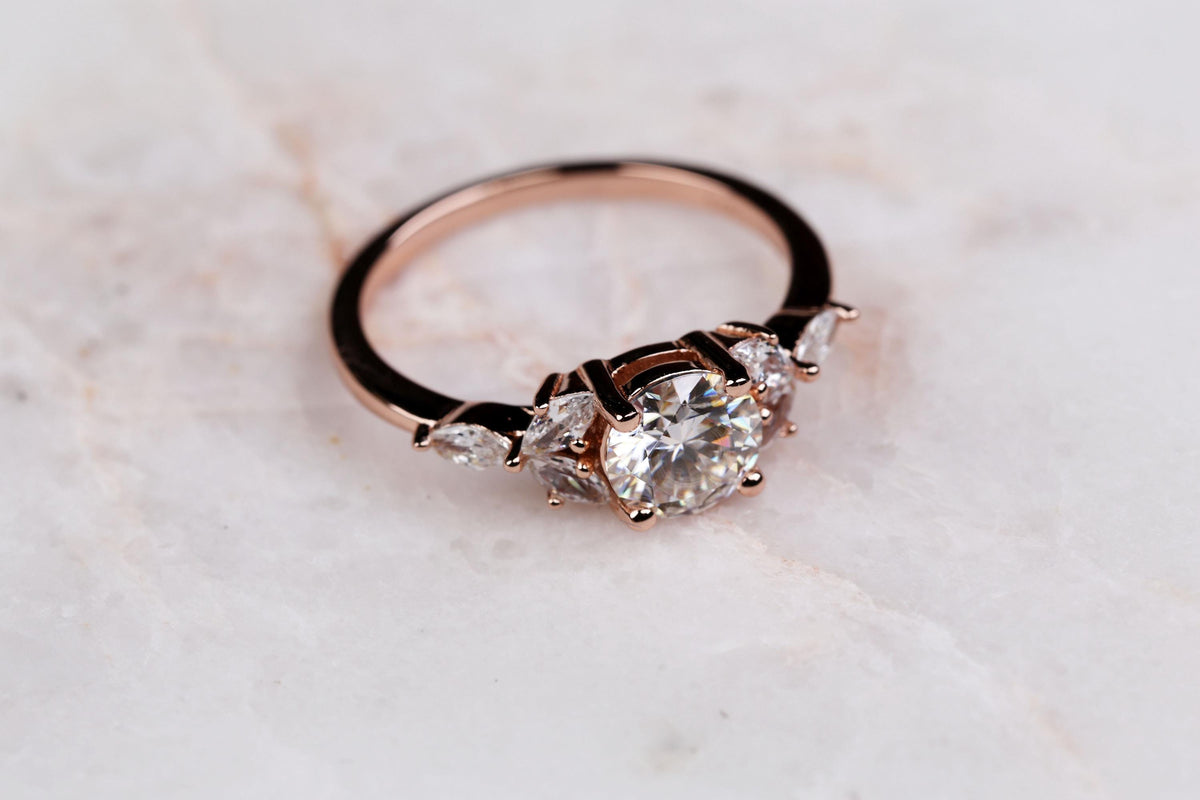 a close up of a diamond ring on a marble surface