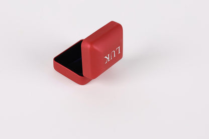 A red metal box with the word "LOUIS" printed on it, sitting on a white background.