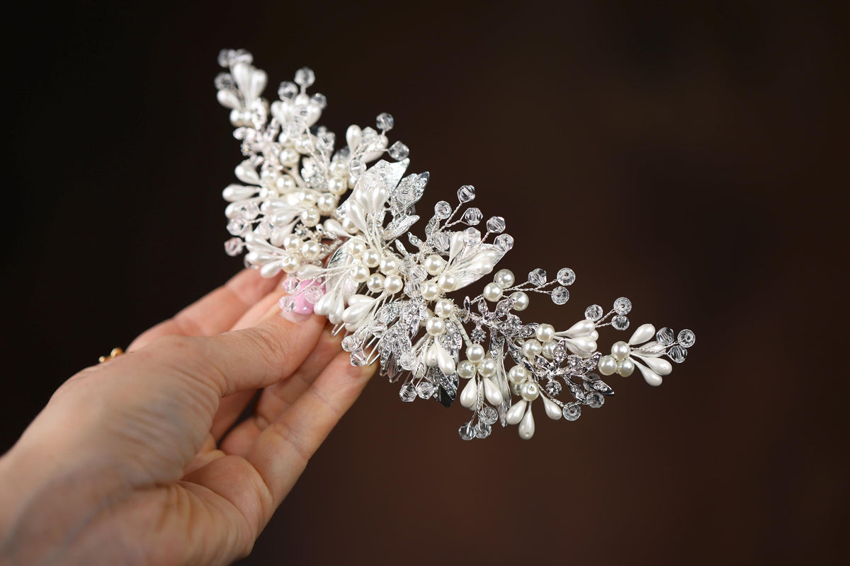 a hand holding a bridal hair piece