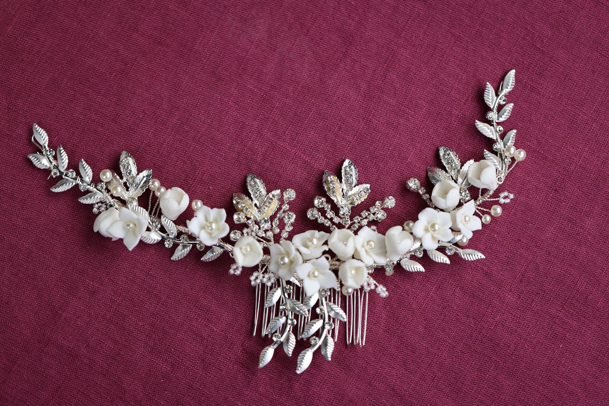a close up of a necklace with flowers and leaves