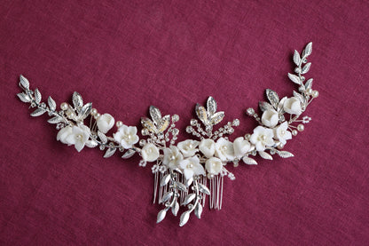 a close up of a necklace with flowers and leaves