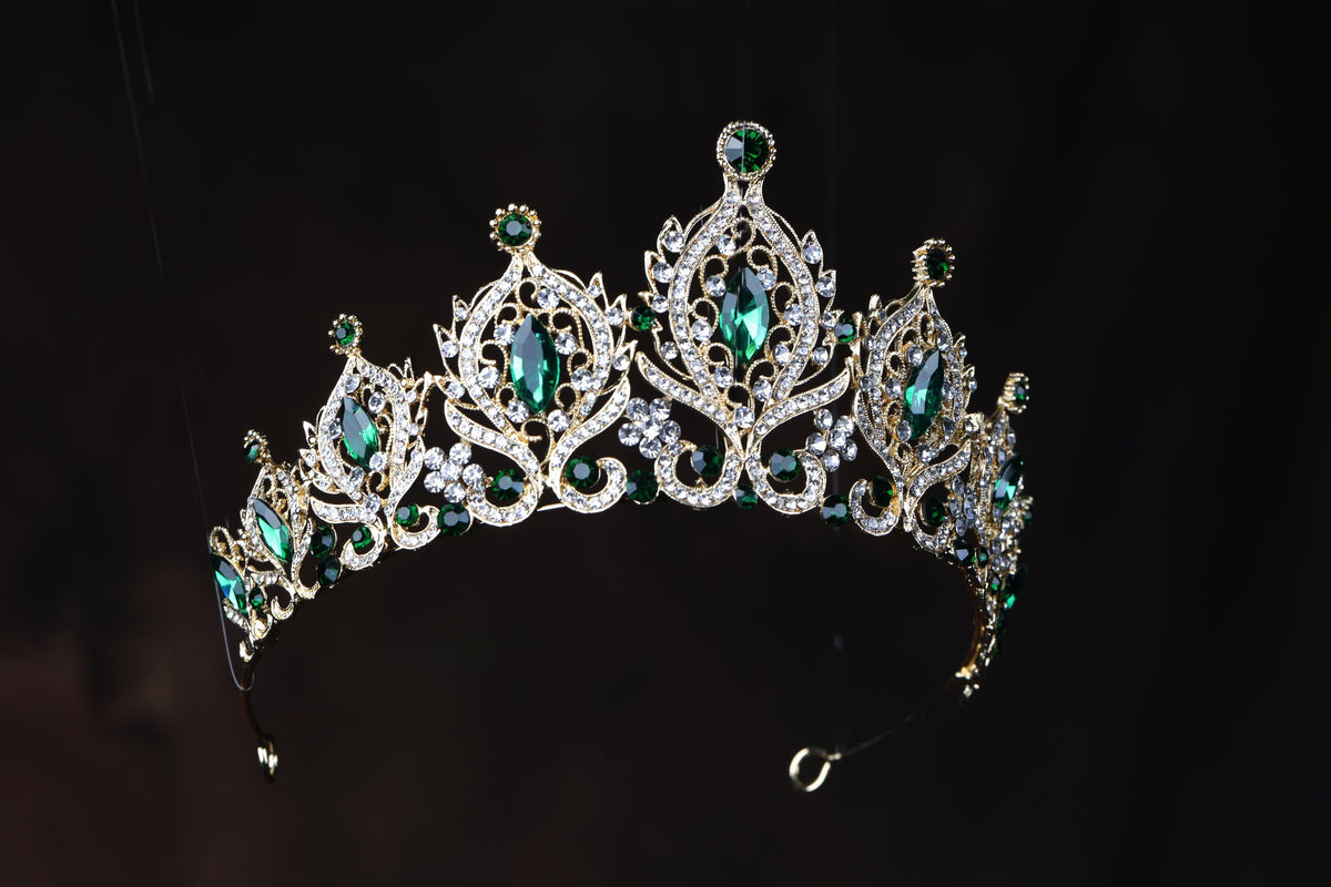 a tiara with green and white stones on it