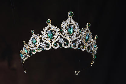 a tiara with green and white stones on it
