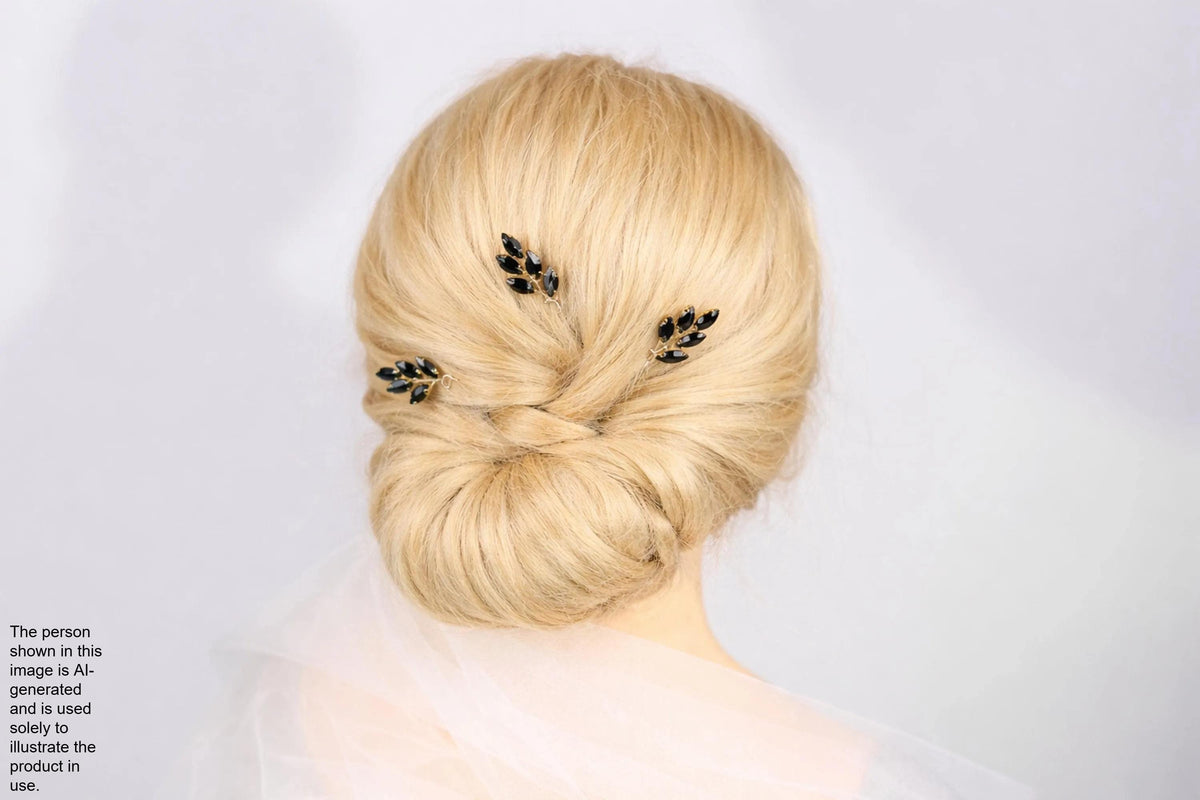 A woman with blonde hair styled in a bun, wearing a veil and three small black leaf-shaped hair clips.