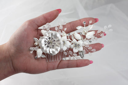 a woman's hand holding a hair comb with flowers on it