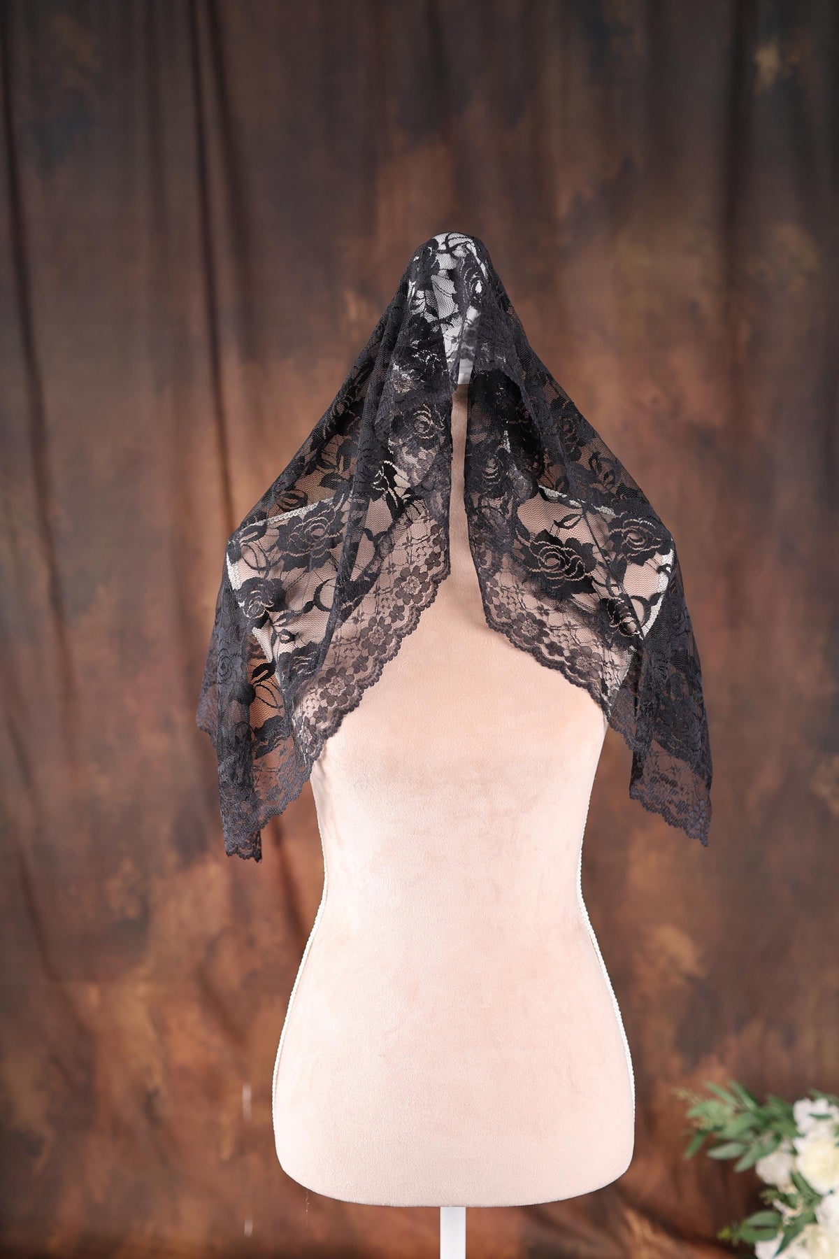 a white mannequin with a black scarf on top of it