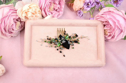 a pink plate with a black and green brooch on it
