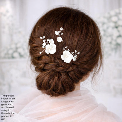 a woman's back view with her hair styled in a bun, adorned with delicate white flower hair clips.