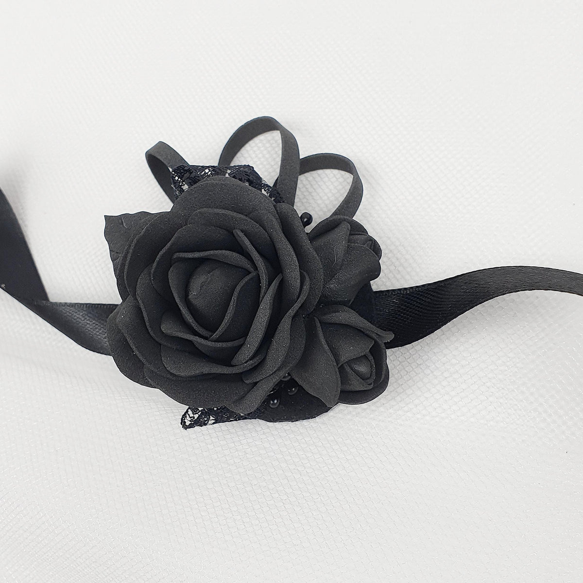a black rose on a black ribbon on a white background