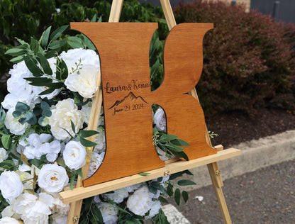 a wooden easel with flowers and greenery around it